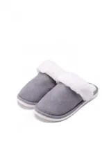 Pantuflas de estar por casa con exterior de gamuza sintética gris y borde de piel sintética blanca, con suela plana.