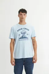Remera de algodón color celeste, con cuello redondo, manga corta y estampa frontal con diseño de volcán y texto.