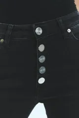 Jean negro de tiro medio alto, corte oxford con botamanga ancha y tajo. Cierre frontal con cinco botones metálicos.