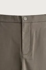 Pantalón de corte slim fit y color negro, confeccionado en tejido elástico. Cuenta con cintura elástica, trabillas, bolsillos frontales y cierre con cremallera y botón.