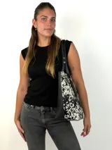 Cartera tipo tote de cuero genuino color marrón oscuro con textura de reptil. Cuenta con doble asa de hombro, cierre superior y un dije colgante de cuero a tono.