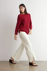 Sweater de punto en color rojo, con cuello redondo, diseño de manga larga y ruedo curvo con terminación acanalada.