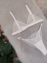 Conjunto de lencería compuesto por un corpiño triangular y una bombacha tipo colaless, confeccionados en encaje con diseño de ondas y detalles en satén.