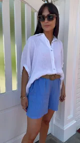 Short de lino color rojo, con cintura elástica y cinturón de rafia con hebilla circular.