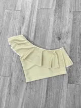 Top corto con un solo hombro y volado grande.