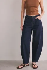 Jean de tiro bajo con fitting baggy y diseño de perneras curvadas, color azul oscuro, confeccionado en denim de algodón con costuras pespuntadas en tono contrastante.