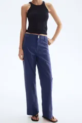 Pantalón de tiro alto confeccionado en lona de algodón, con diseño de pierna recta, raya marcada en el frente y la espalda, cierre con botones metálicos y bolsillos de parche en la parte posterior.