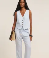 Pantalón fluido Marfinno modelo pijama, color blanco, confeccionado en viscolino. Cuenta con cintura elástica en la espalda, lazo de ajuste, pliegues frontales y bolsillos laterales.