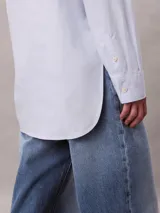Camisa de popelina de algodón de corte relaxed, color celeste, con cuello clásico, cierre frontal con botones y bolsillo en el pecho con monograma CK bordado.