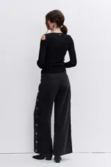 Blusa de punto acanalado color negro, con diseño de hombros descubiertos y manga larga.