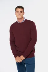 Buzo tejido de lana con escote redondo a la base, de manga larga y calce clásico.