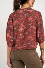 Blusa estampada de manga larga color bordó, confeccionada en viscosa, con escote en V y detalles de encaje en el cuello y las mangas.