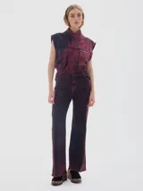 Pantalón de jean de mujer, corte flare con tiro medio, teñido en color bordeaux con efecto lavado y desgaste en las costuras.