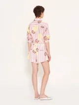 Short de lino con estampado de rayas verticales rosas y blancas, con flores amarillas y marrones.