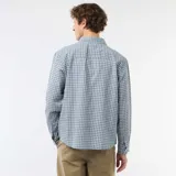 Camisa de manga larga con diseño de cuadros en tonos azules y blancos, cuello camisero y cierre frontal de botones.