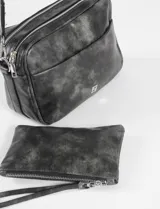 Bandolera pequeña de cuero sintético marrón con efecto desgastado, con doble cierre y estuche removible. Tiene una correa de tela ajustable en color beige.