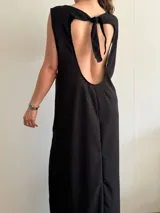 Vestido largo negro de tejido texturizado, sin mangas y con escote bote. Presenta dos tajos laterales altos.
