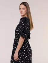 Vestido midi de calce holgado y caída fluida con escote en V cruzado, cintura elastizada fruncida y mangas cortas con volados superpuestos. Cuenta con un diseño estampado de flores grandes en tonos amarillo, blanco, azul marino y verde.