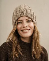 Gorro tipo beanie de tejido de punto grueso con diseño acanalado, confeccionado en lana natural sin teñir.