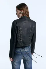 Campera de cuero merino negro con diseño de tientos entrelazados en el frente y la espalda, cierre frontal con botones metálicos y corte entallado.