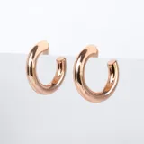 Aros tipo argolla oro rosa con diseño inflado, abiertos, con pasante y fru fru.