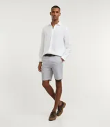 Bermuda slim de lino y algodón color beige, de corte ajustado, con trabillas para cinturón y bolsillos laterales y traseros.