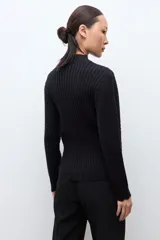 Sweater de punto color crudo con cuello alto tipo media polera, manga larga y diseño con textura de líneas horizontales. Presenta un borde inferior con terminación ondulada.