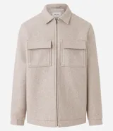 Campera pesada tipo trucker de polivelour color beige, con cuello camisero, cierre frontal por cremallera y dos bolsillos frontales con solapa en el pecho.