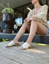 Sandalias chatas de cuero color crudo, fabricadas en Uruguay.