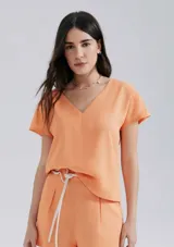 Blusa color naranja de lino, con escote en V y mangas cortas.