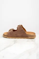 Sandalias marrones de cuero con dos tiras anchas ajustables con hebillas doradas. La plantilla es de corcho y la suela es de goma.