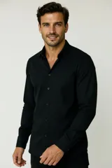 Camisa de corte holgado, color blanco, con cuello clásico, cierre frontal de botones y bolsillo en el pecho.