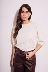 Remera de algodón color blanco roto, con escote redondo y mangas globo de tres cuartos con elástico en el puño.