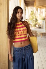 Top tejido a mano con diseño de cuello halter, confeccionado en hilo con un patrón geométrico multicolor que incluye tonos amarillos, rosas, celestes y blancos.