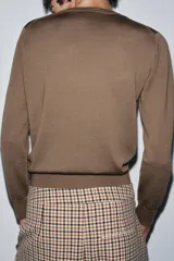 Jersey básico de cuello redondo y manga larga, confeccionado en hilatura de lana 100% con acabado de punto liso.