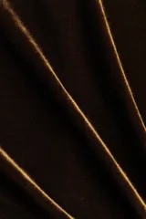 Vestido mini de velour con escote redondo y mangas largas con hombreras. Presenta un diseño ajustado con detalle de drapeado, nudo lateral y una tira larga que cae sobre la falda. Incluye cierre oculto en la espalda.