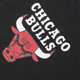 Short de básquet negro con detalles en rojo, cintura elástica con cordón ajustable, diseño con el logo y nombre de los Chicago Bulls y los bordes inferiores en color rojo.