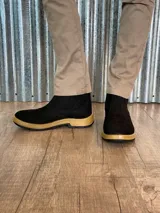 Botín marrón de cuero con elásticos laterales, suela de goma color caramelo y puntera reforzada.