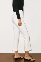 Pantalón mini flare de tiro medio, color negro, con diseño evasé y raya central marcada. Cuenta con cierre lateral mediante cremallera oculta.