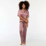 Conjunto de pijama largo de dos piezas con camisa de manga corta con botones y pantalón largo con estampado geométrico en tonos púrpura, rosa y blanco.