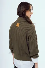 Sweater de tejido de punto color bordó, con cuello alto, cierre frontal parcial y mangas largas.