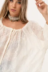 Blusa color crudo con bordado de flores, escote cuadrado y mangas 3/4 abullonadas.