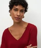 Blusa básica de punto leve color marrón, con escote en V, mangas largas y cuello con textura acanalada. Presenta un corte regular y diseño liso.