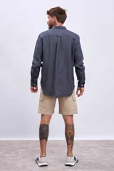 Camisa de manga larga para hombre, con cuello clásico y botones frontales. Presenta un estampado de rayas verticales finas en tonos azul claro y blanco.