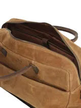 Maletín de suede marrón claro con asas cortas de cuero liso, bolsillo frontal con cierre y detalles metálicos en tono bronce.