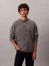 Sweater de punto Calvin Klein gris melange, con cuello redondo, manga larga y logo institucional "ck" en relieve en el centro del pecho. Corte regular.