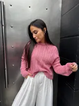 Sweater color crema tejido con diseño en ochos y cuello redondo.