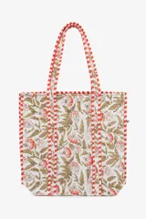 Bolso tipo tote acolchado con estampado floral en tonos beige y coral, con detalles de ribetes a rayas rojas y blancas en las asas y bordes.
