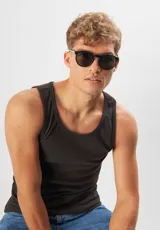 Lentes de sol redondos con montura gris translúcido y lentes verdes. Fabricados con acetato biodegradable y lentes de PMMA reciclado.