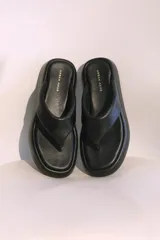 Sandalias negras de cuero sintético con plataforma y diseño de tanga.